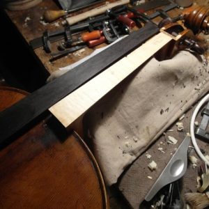 Travail du manche d'un violon sur un établis de luthier