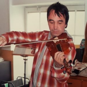 Homme portant une chemise à carreaux jouant du violon