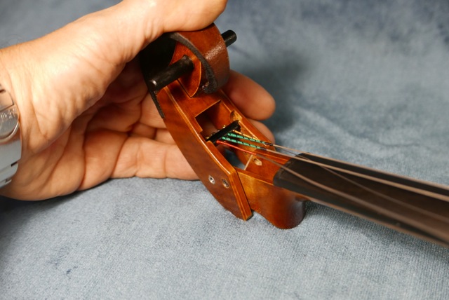 main d'un luthier tenant la volute d'un violon